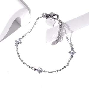 Macro view of silver bracelet with diamond-cut zircons, lobster clasp and heart charm