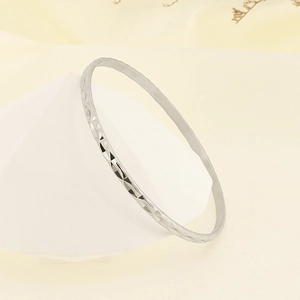 Detail of silver titanium steel bangle featuring intricate diamond-cut faceted patterns