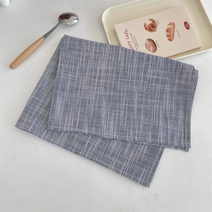 Gros plan de sets de table en coton et lin à rayures bleues et blanches aux coutures nettes
