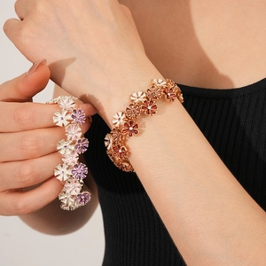 Detailansicht der Blumen-Emaille-Armbänder mit rosa und braunen Anhängern und Kristallen