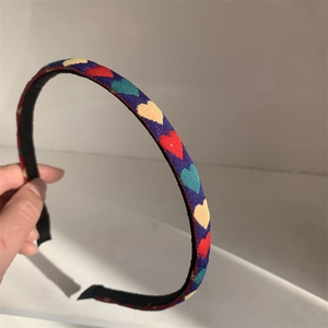 Navy blue fabric headband with colorful heart patterns shown against a white background