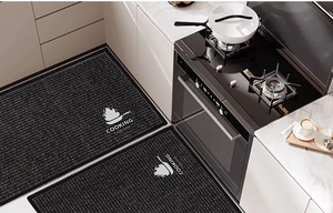 Detail of black non-slip kitchen mats with Cooking and Food Time text in modern kitchen