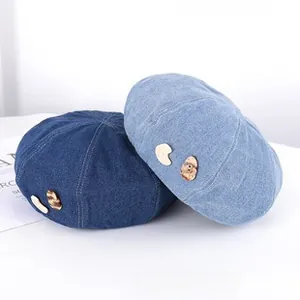 Detailed view of light and dark blue denim berets with textured decorative accents