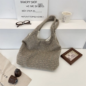 Detail of taupe tweed tote bag featuring white fabric lining and large capacity design