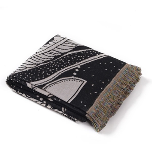 Detailed texture of black and white bohemian knit throw blanket with colorful fringe trim
