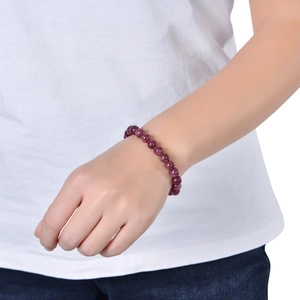 Close-up of deep purple amethyst natural stone beaded bracelet worn on a woman's wrist