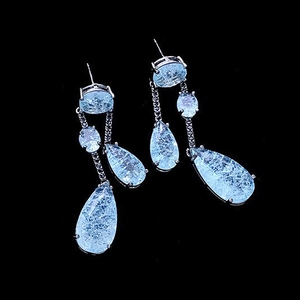 Elegant waterdrop drop earrings with light blue gemstones on a sleek black background