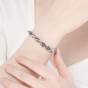 Close-up of a minimalist silver titanium steel chain bracelet worn on a person's wrist