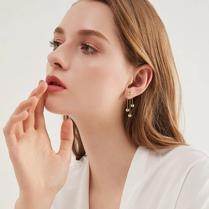 Elegant gold metal ball tassel drop earrings shown on model with cascading chain design