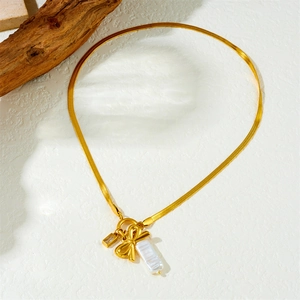 Elegant gold snake chain necklace featuring a bow pendant and baroque pearl charm