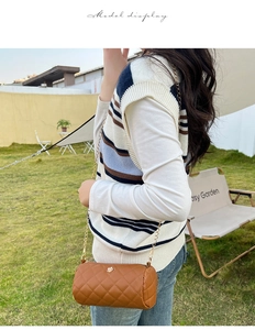 Brown quilted cylindrical crossbody bag with gold chain strap and floral embroidery details