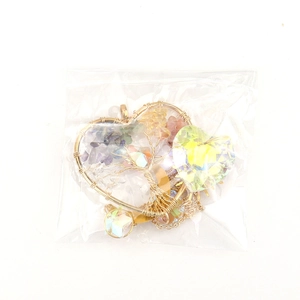 Close-up of heart-shaped tree of life suncatcher with colorful stones and crystal charm