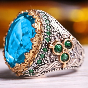 Macro shot of vintage ring featuring a blue oval gemstone and detailed floral engraving
