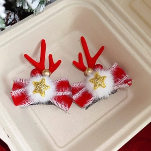 Close-up of festive Christmas hair clips with red reindeer antlers and snowflake bows