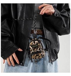 Close-up of leopard print mini crossbody bag with metal zipper and fashion woven label