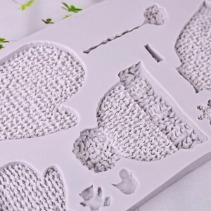 Grey silicone mold for Christmas knitted sweater hat and glove themed cake decorations