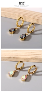 Detailed close-up of gold plated hoop earrings with iridescent teardrop zircon pendants