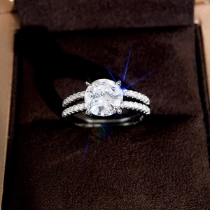 Macro shot of a four-prong round moissanite ring with split shank and diamond-paved accents