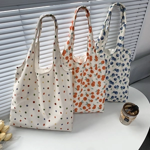 Detailed trio of canvas tote bags featuring vibrant polka dot and fruit print designs