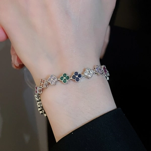 Close-up of a zircon clover bracelet with multicolor stones on a silver-tone chain