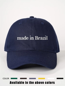 Detailed close-up of white 'Made in Brazil' embroidery on a navy cotton baseball cap