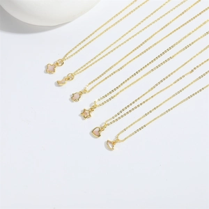 Detail of six gold pendant necklaces featuring moon, heart, and clover motifs with inlay