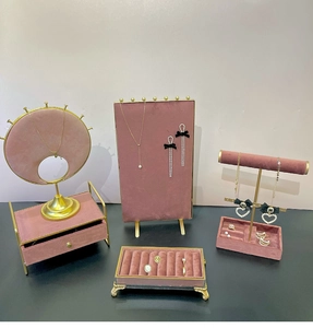 Pink velvet and gold metal jewelry display set featuring necklace stand and ring tray