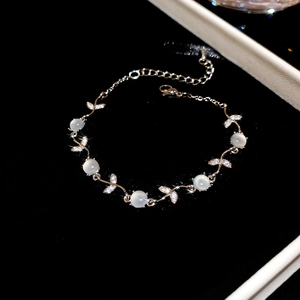 Détail du bracelet fleur papillon en zircon avec opales sur fond de velours noir