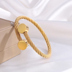 Elegant 18k gold plated stainless steel twisted wire cuff bracelet on white silk