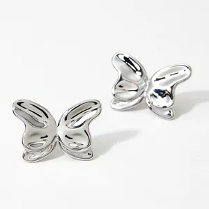 Macro shot of silver butterfly stud earrings with high-polish finish on white background