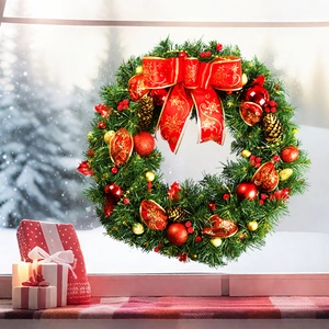 Christmas wreath with red bows and gold ornaments set against a snowy window scene