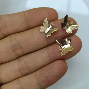 Three gold butterfly pendants with detailed wings and loops for DIY jewelry making