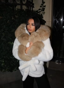 Détail d'une veste blanche en fausse fourrure avec grand col en peluche doux