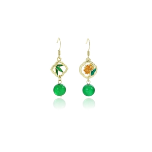 Detailed close-up of golden bamboo leaf earrings with green beads and enamel finish