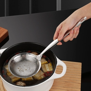 304 stainless steel fine mesh skimmer spoon filtering oil from soup in a kitchen pot