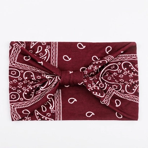 Detail of burgundy sweatband featuring white paisley pattern and stylish knotted design