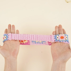 Detail shot showing the high elasticity of a soft hand-knitted floral headband