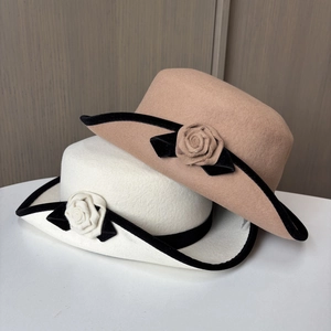 Détail de chapeaux en feutre de laine avec bordure en velours et fleurs de camélia à la main