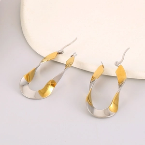 Detailed view of U-shaped earrings with twisted design in two-tone gold and silver finish