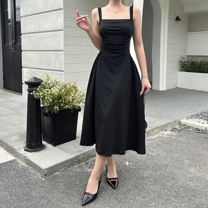 Detail of the high-waisted shirred bodice and square neckline on a black A-line dress