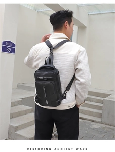 Rear view of black waterproof nylon crossbody chest bag with adjustable shoulder strap