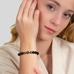 Bracelet en perles noires mates avec lettre A et cœurs porté au poignet femme