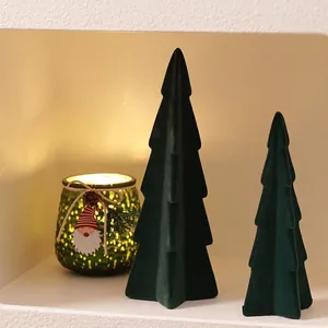 Green flocked ceramic Christmas tree set with glowing candle holder in a cozy niche