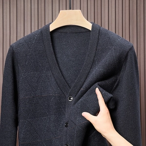 Detaillierte Nahaufnahme der dunkelblauen Strickstruktur und Knöpfe an einem Herren-Cardigan