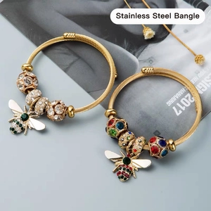 Golden stainless steel wire woven bangles with sparkling crystal bee charms