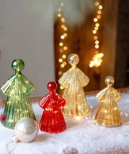 Macro view of mercury glass angels with vertical textures and LED warm white glow