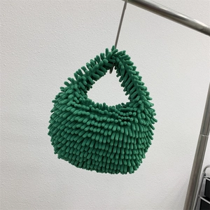 Detail view of emerald green chenille plush handbag featuring unique woven textured fabric