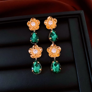 Vue détaillée des boucles d'oreilles fleur vintage en or 18 carats avec gemmes vertes