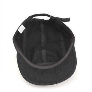 Internal view of black cotton 5-panel cap showing stitched seams and adjustable strap
