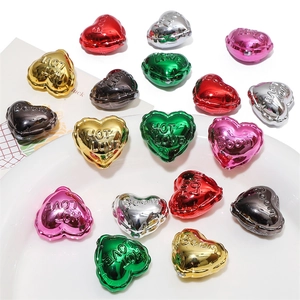 Macro detail of acrylic heart beads with hot love engraving and metallic finish